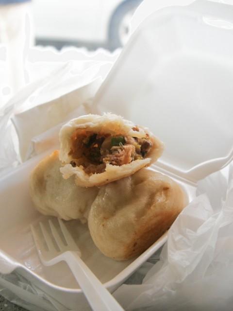 Three dumplings in a to-go container.